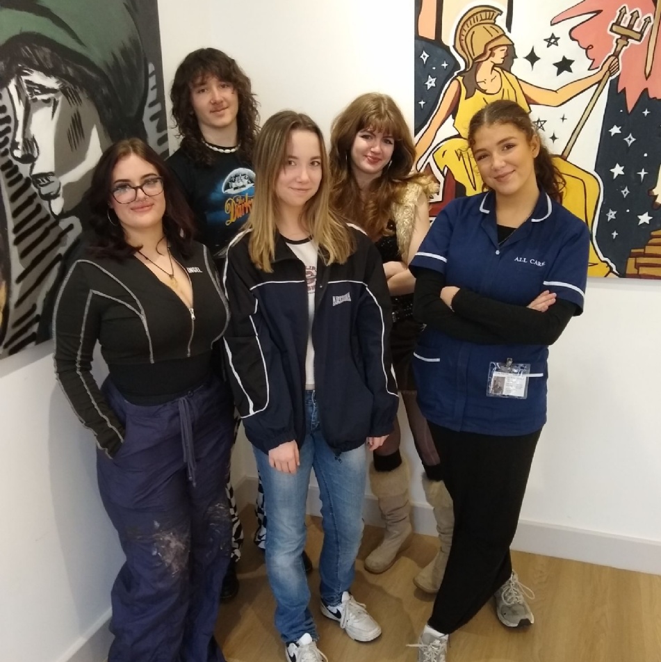Five students standing in front of artwork